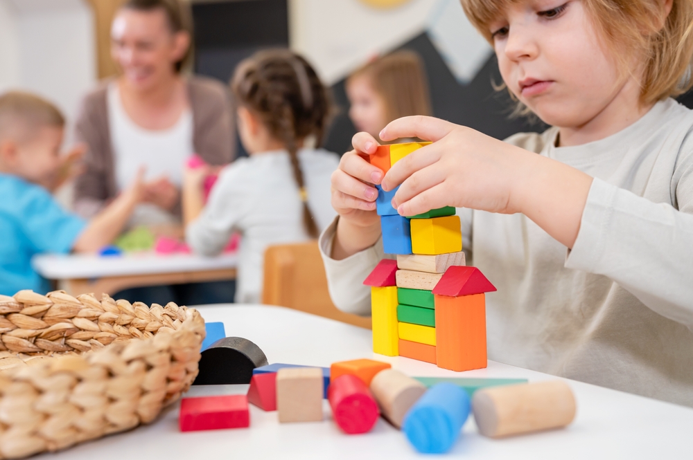 Kindergarten children playing with colorful building blocks. Healthy learning environment. Learning through play.