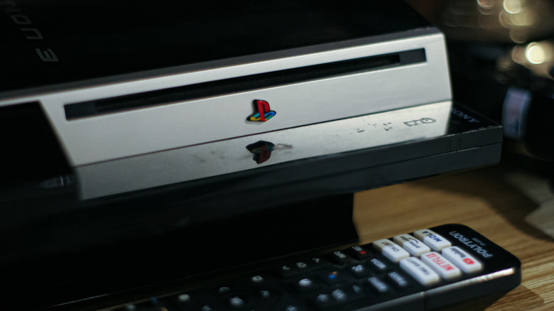 PlayStation 3 console behind a TV remote
