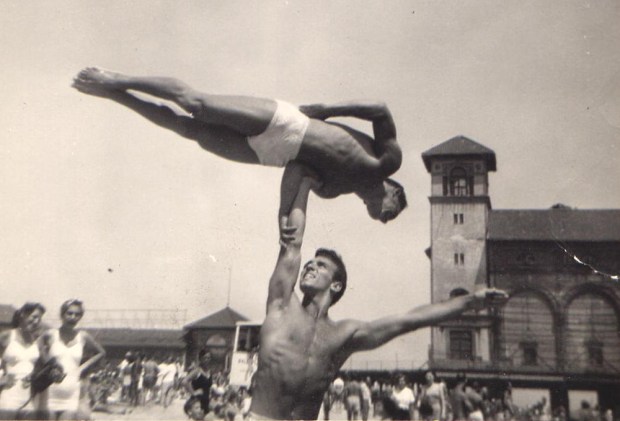 Longtime San Diegan Stan Levin, top, practicing acrobatics with a friend on Mission Beach in 1962. He passed away June 8 at age 96. (The Levin Family)