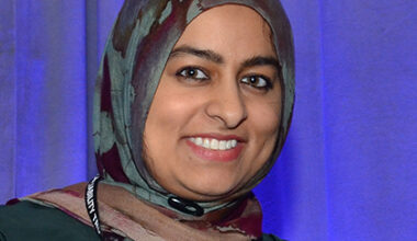Smiling woman wearing a head scarf.