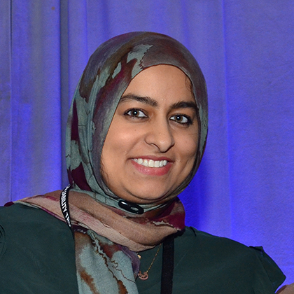 Smiling woman wearing a head scarf.