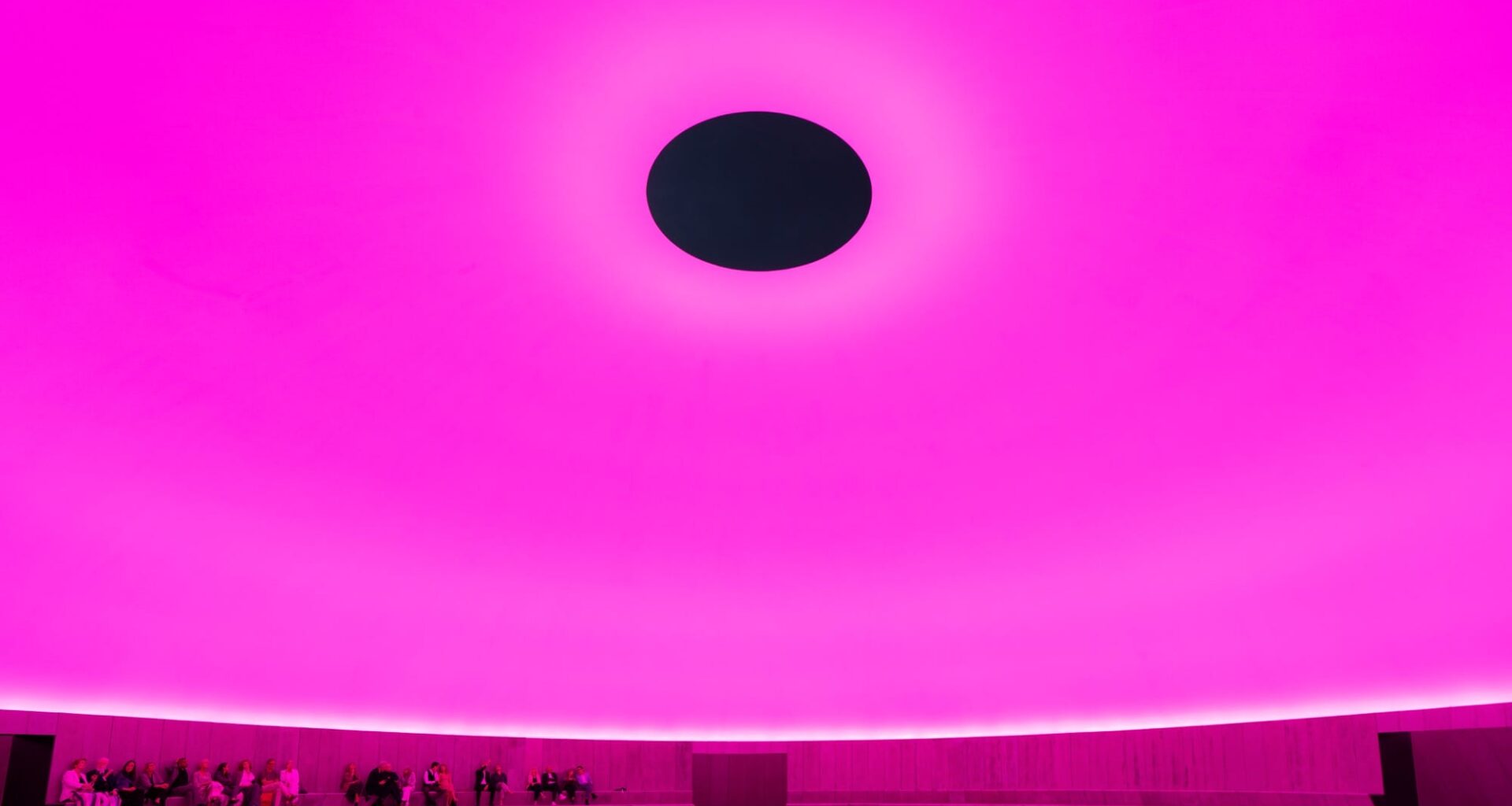 Visitors sit inside of James Turrell