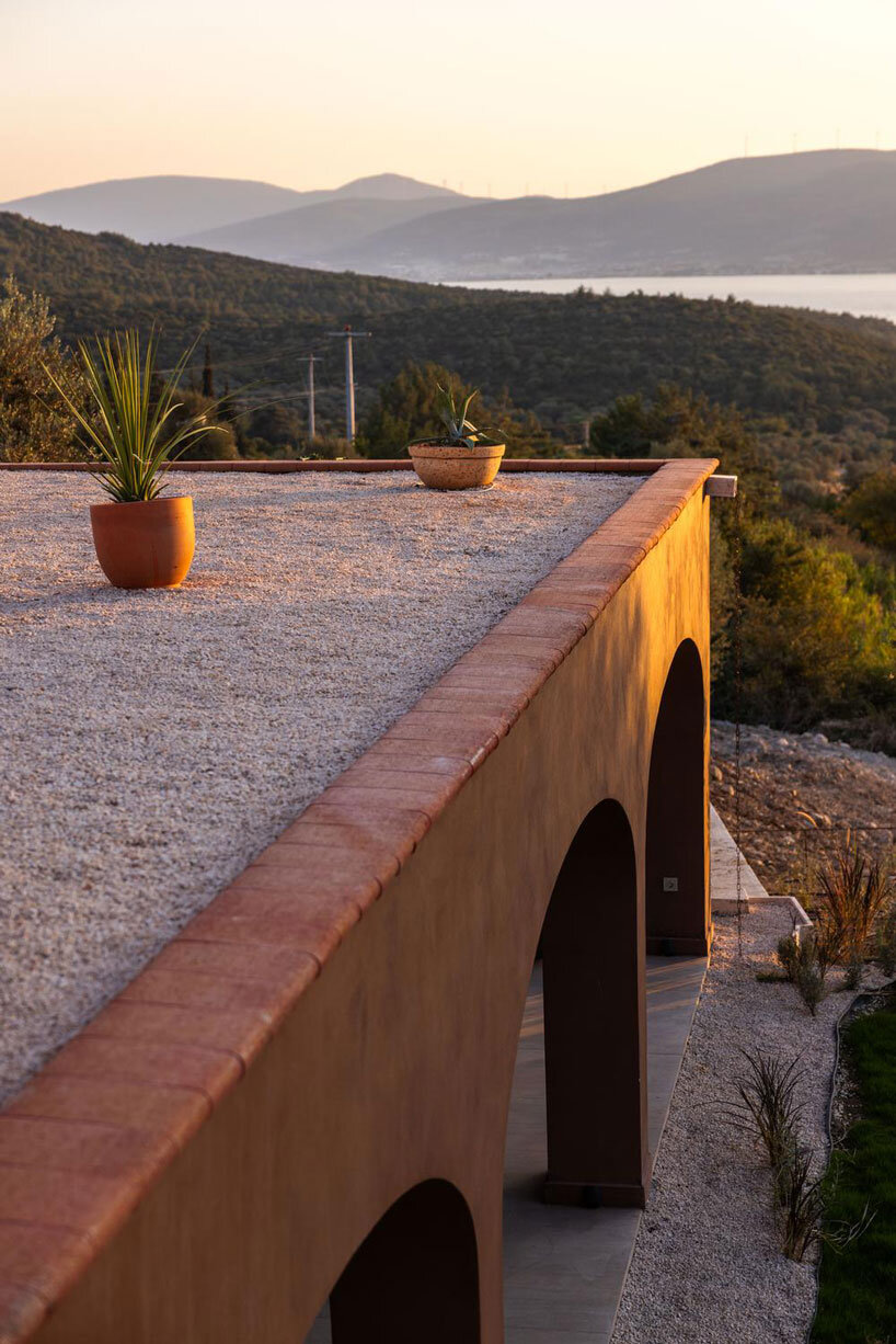 lime-washed facade in terracotta tones enfolds urla family home in turkey