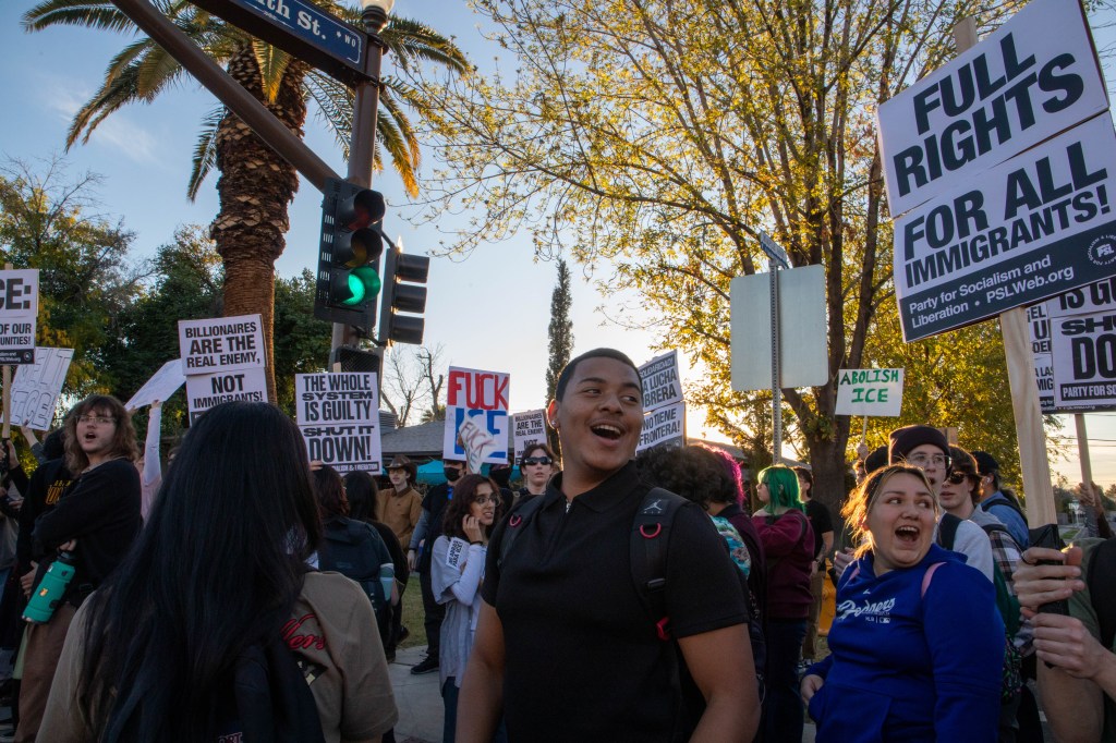 students hold anti-trump signs