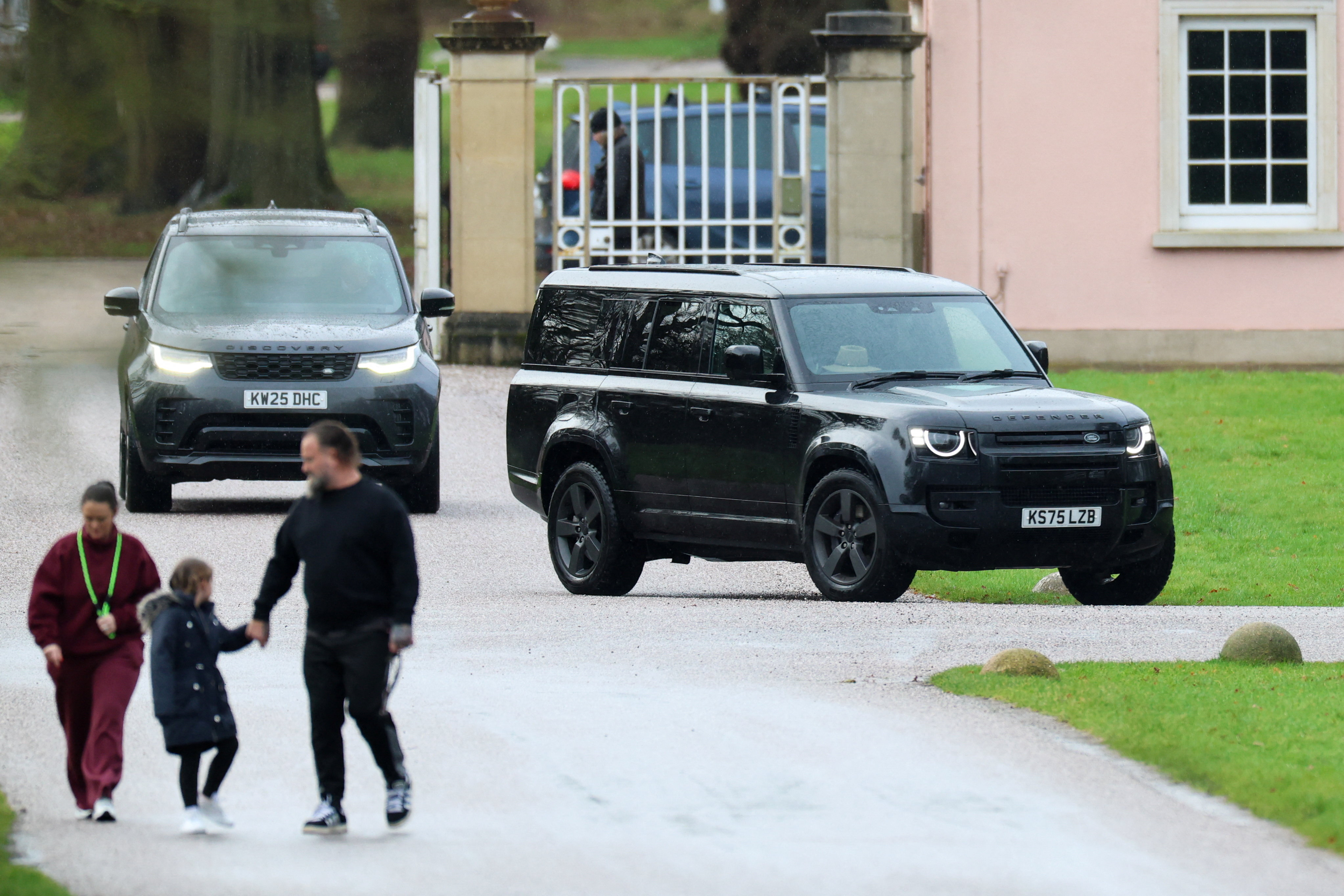 A black SUV believed to be transporting Andrew Mountbatten-Windsor drives near a gatehouse.