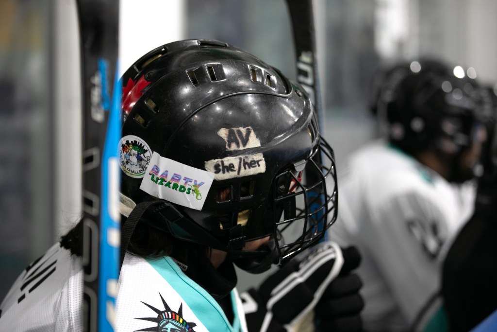 A New York City Pride Hockey Alliance player has her gender pronouns taped on her helmet.