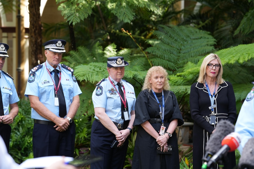 A group of police officers standing at a press conference