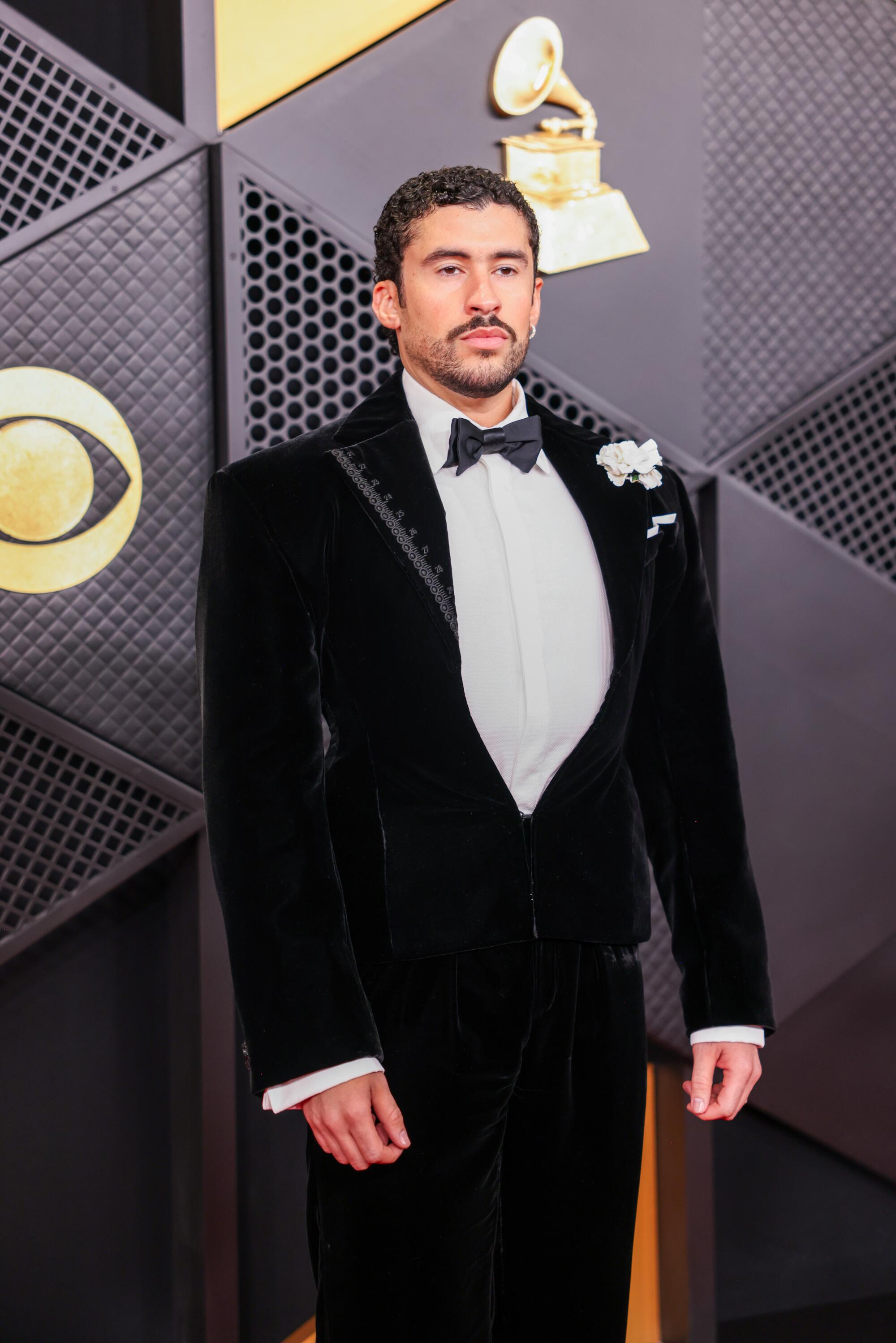 Bad Bunny, wearing a velvet tux, poses on the red carpet. 