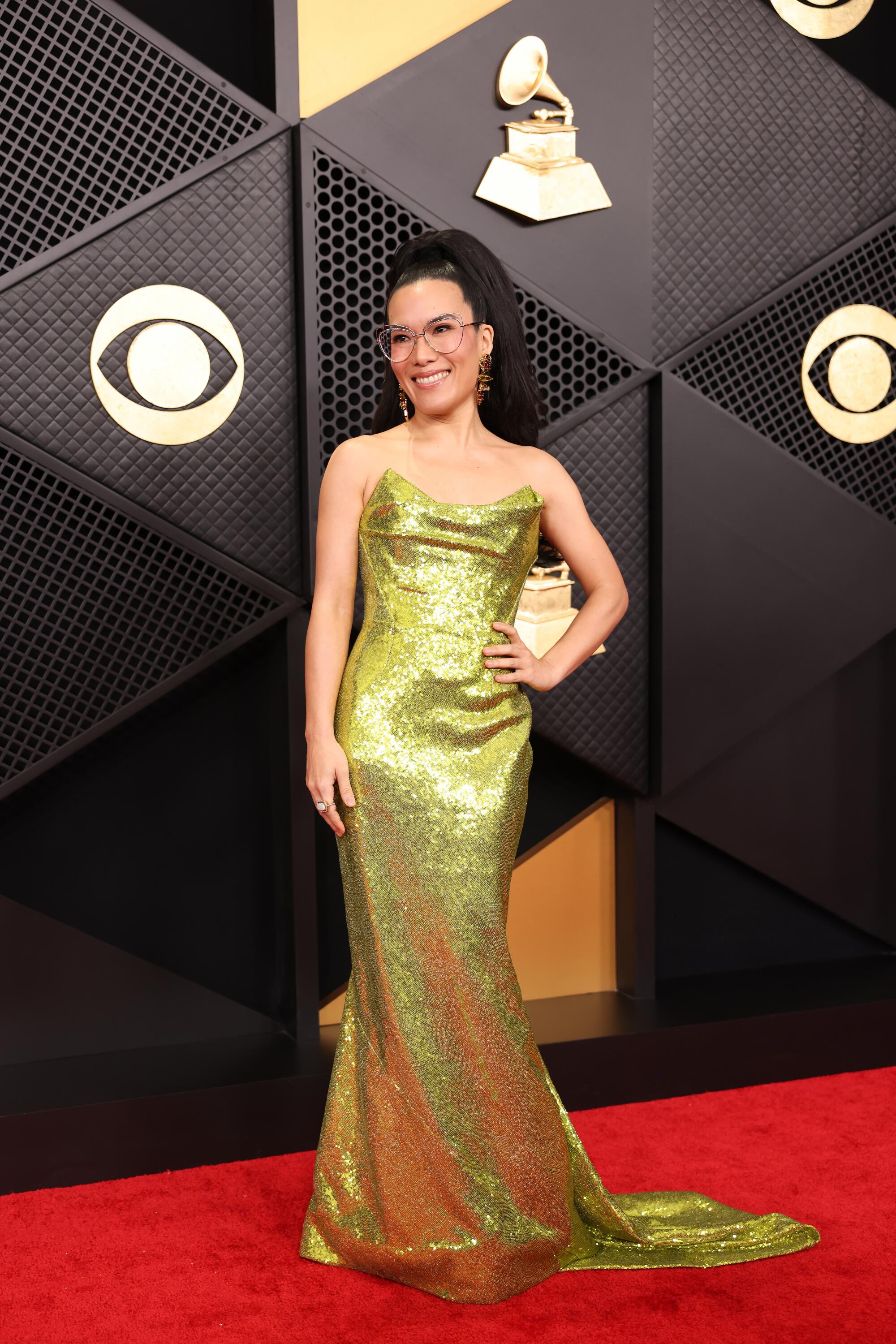 Ali Wong, in a green gown, poses on the red carpet. 