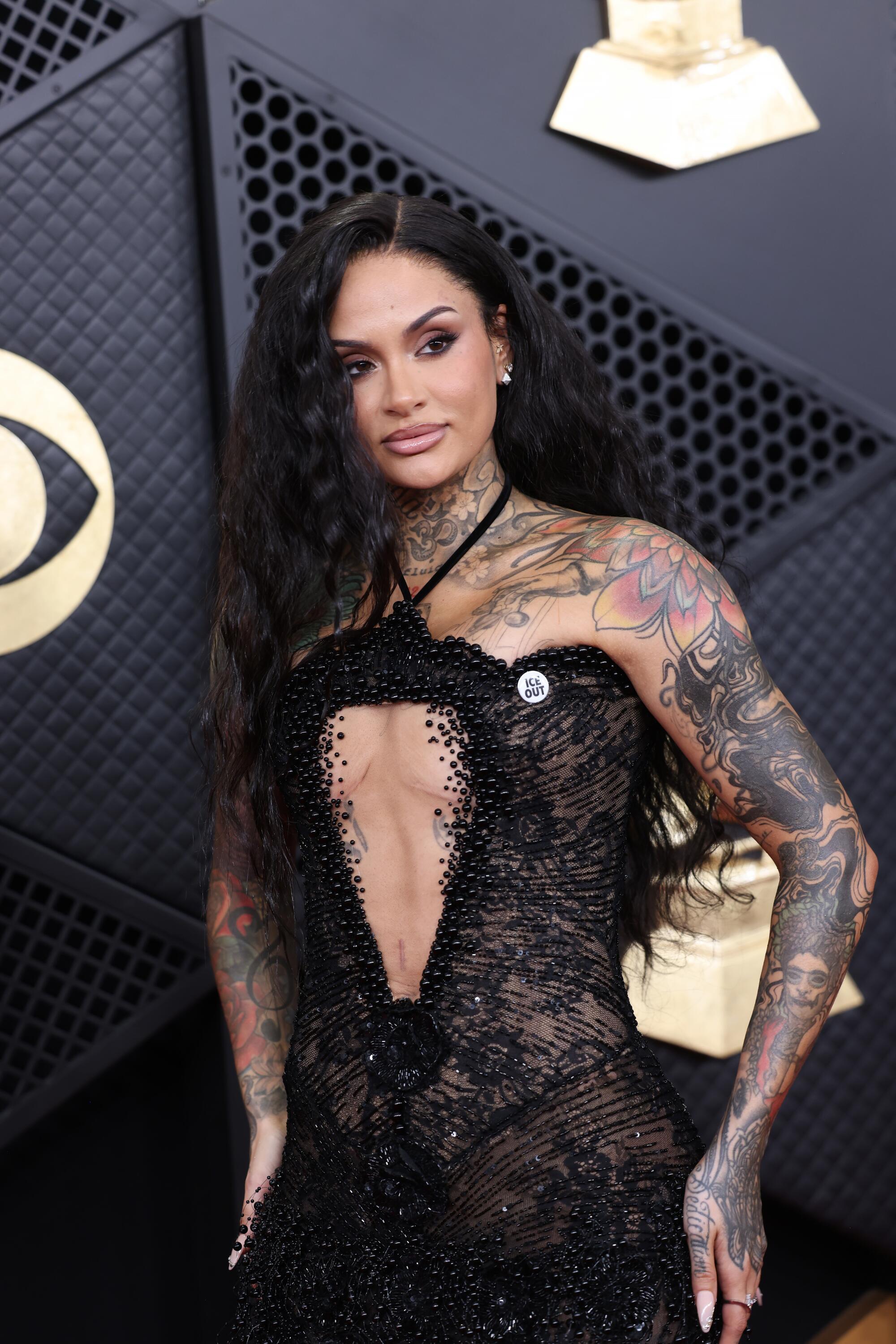 Kehlani, in a lace black gown, poses on the red carpet. 