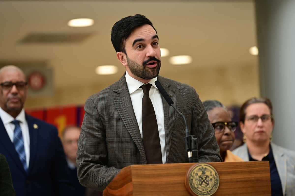 Mayor Mamdani in a suit at a podium