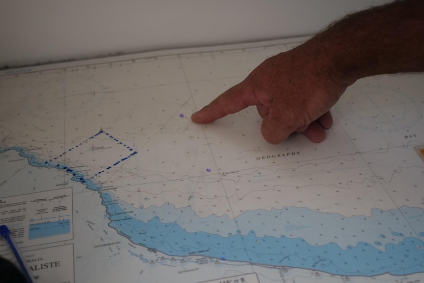 A marine rescue volunteer points to where the family was found.