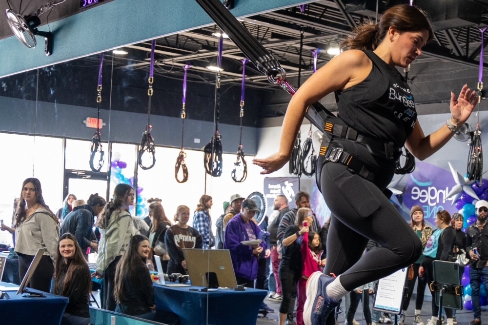 Onlookers watch someone doing bungee fitness.