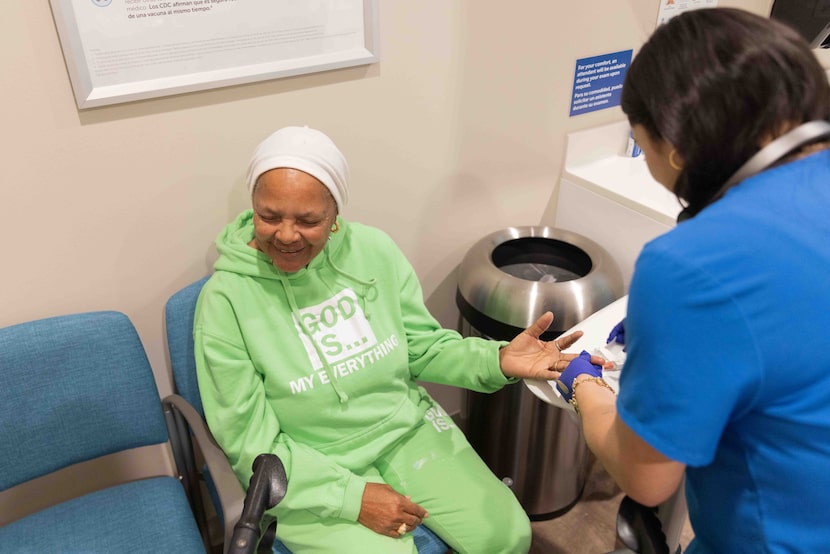 (From left) Wirries Konadu closes her eyes as medical assistant Jennifer Yeh prepares to...