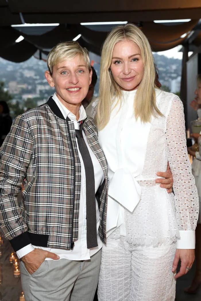 Ellen DeGeneres and Portia de Rossi stand together indoors