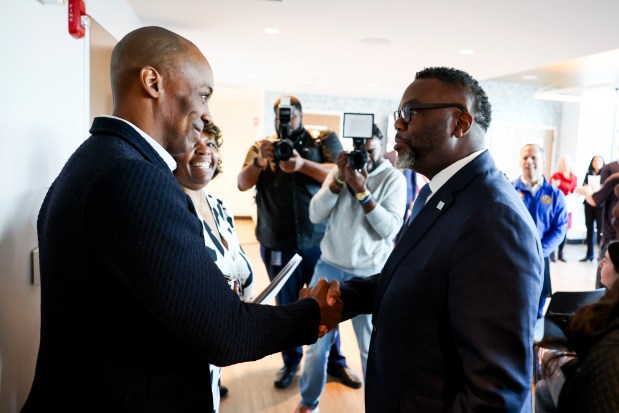 Mayor Brandon Johnson, right, shakes hands with Matthew Brewer, interim chairman of the Chicago Housing Authority, during a ribbon-cutting event for the Edith Spurlock Sampson Apartments in the Lincoln Park neighborhood on Feb. 27, 2025. (Eileen T. Meslar/Chicago Tribune)