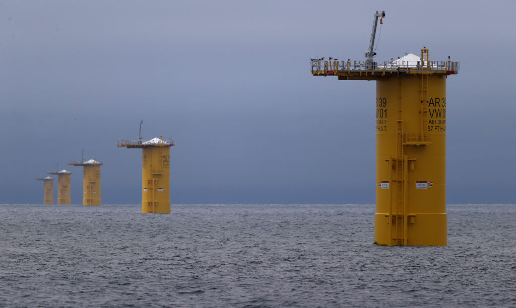 Image of a series of metal cylinders rising vertically from the ocean.