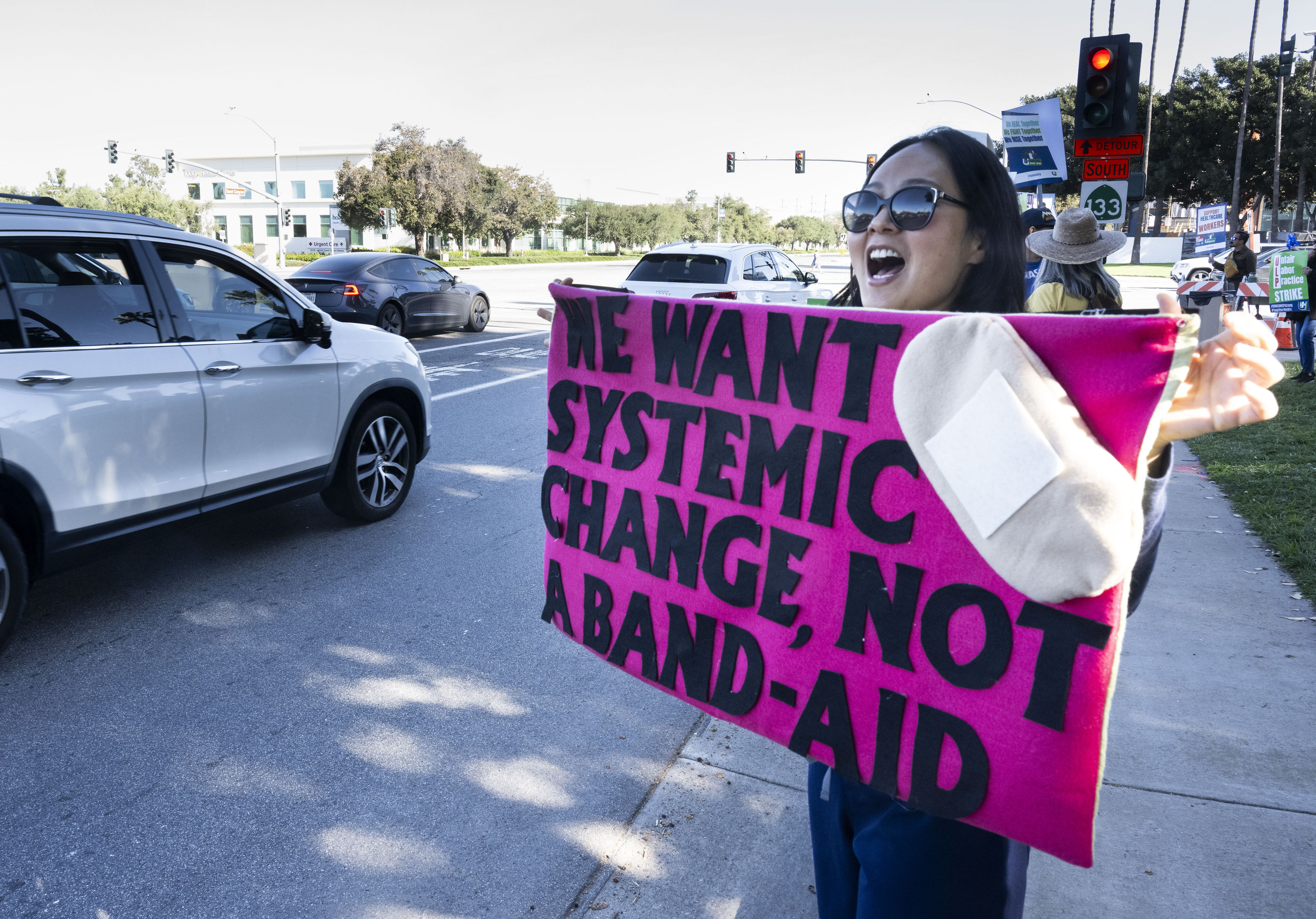 A woman protests with others at Kaiser Permanente on Alton...
