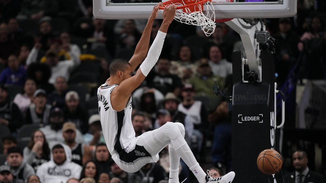 San Antonio Spurs forward Victor Wembanyama (1) scores against the Orlando Magic during the first half of an NBA basketball game in San Antonio, Sunday, Feb. 1, 2026. (AP Photo/Eric Gay)