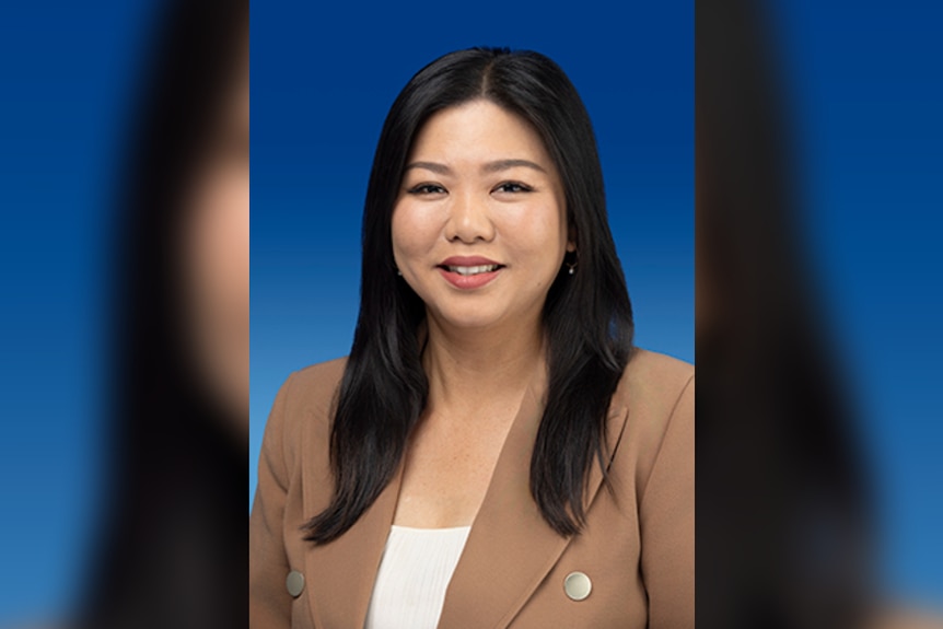 Sook Yee Lai stands in front of a blue background.