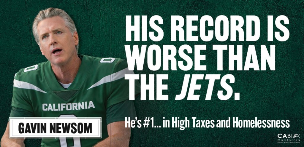 A billboard depicting Governor Gavin Newsom in a New York Jets uniform with the text "His Record is Worse Than The Jets. He's #1... in High Taxes and Homelessness."