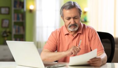 Serious person holding pen and reading document.
