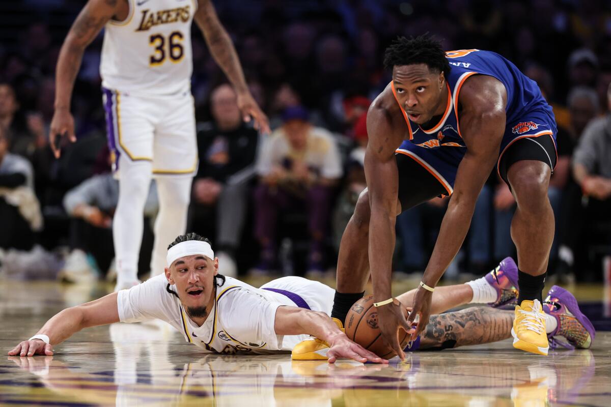 Lakers center Jaxson Hayes, left, dives for a loose ball next to Knicks forward OG Anunoby in the first half Sunday.