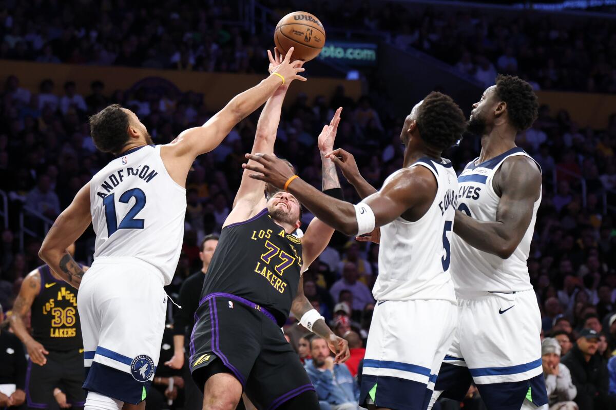 Luka Doncic puts up a shot while triple-teamed in the second half.