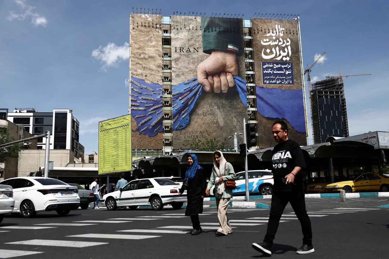 People walk past a billboard with a graphic design about the Strait of Hormuz amid a ceasefire in Tehran, Iran, on Monday.