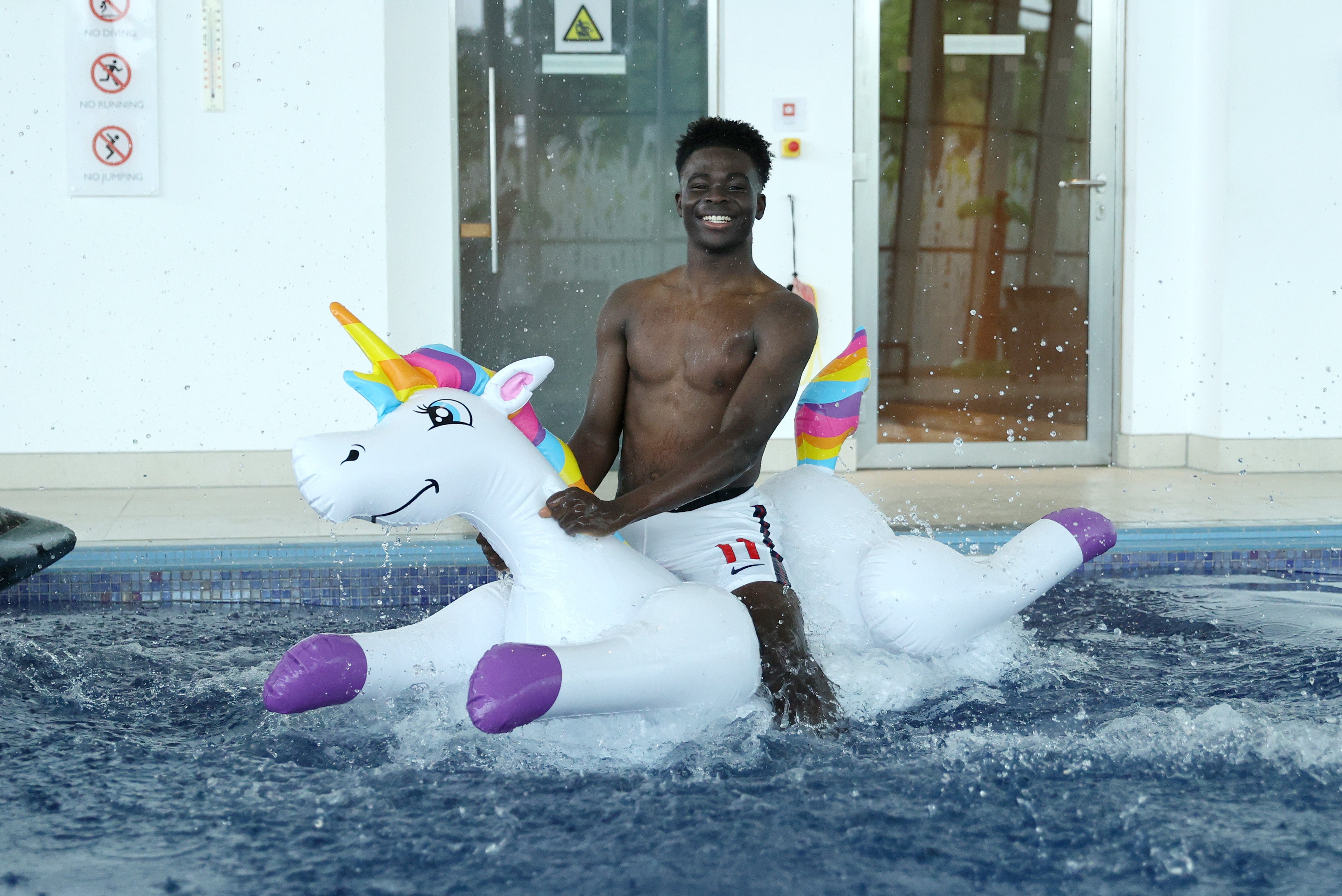 Bukayo Saka had an inflatable in the swimming pool, although not a unicorn as he had in an England training camp ahead of Euro 2020 (pictured)