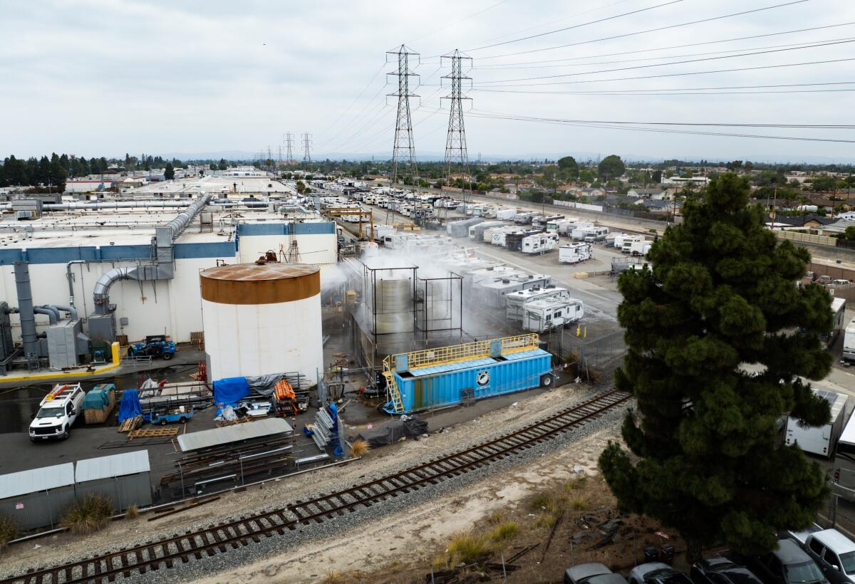 An aerial view shows water being sprayed on large storage tanks at the GKN Aerospace facility on Sunday in Garden Grove.