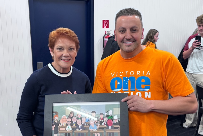 Pauline Hanson poses for a photo with Michael Piastrino, who is wearing an orange One Nation t-shirt.