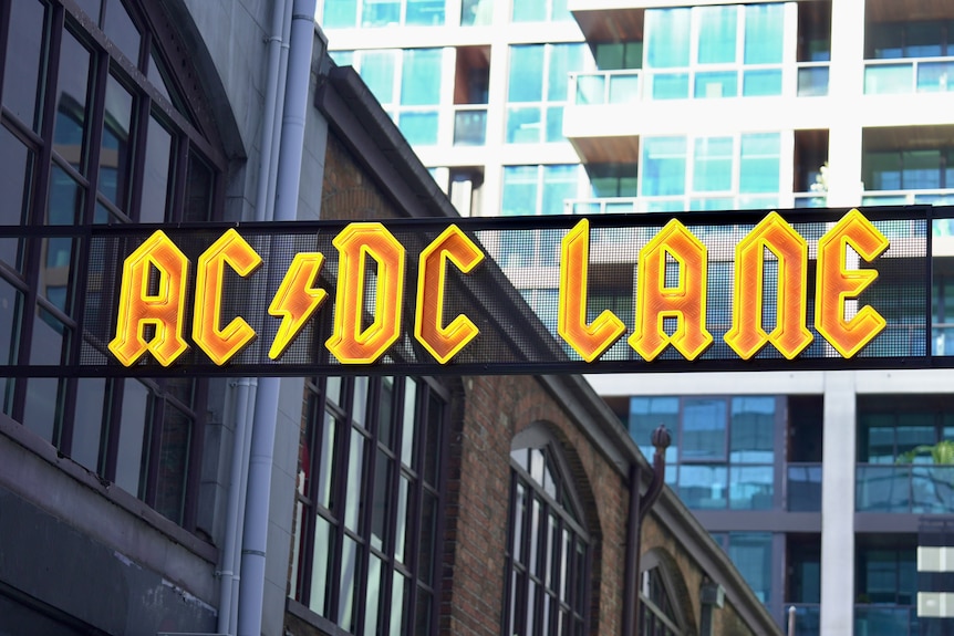A yellow and orange sign in the ACDC font reads 'ACDC Lane'