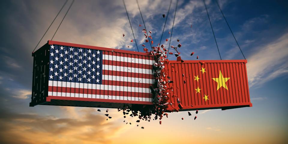 Trade war depicted as two swinging container shipping boxes with US and China flags crashing into each other.