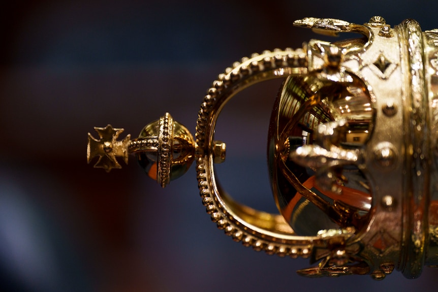 A gold plated ceremonial tool laying on a desk