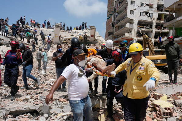 Rescue workers carry Daniel Cordero after pulling him from the rubble two days after an earthquake struck Catia la Mar, Venezuela, Friday, June 26, 2026. (AP Photo/Fernando Vergara)