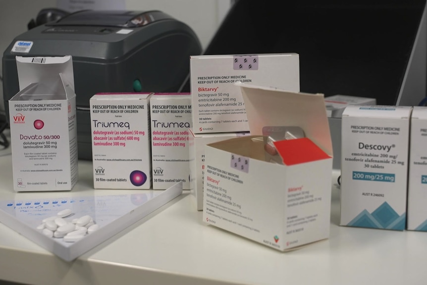 Boxes and bottles of white pills on a white tabletop