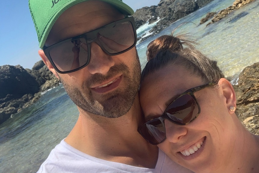 A man and a woman hug on the beach