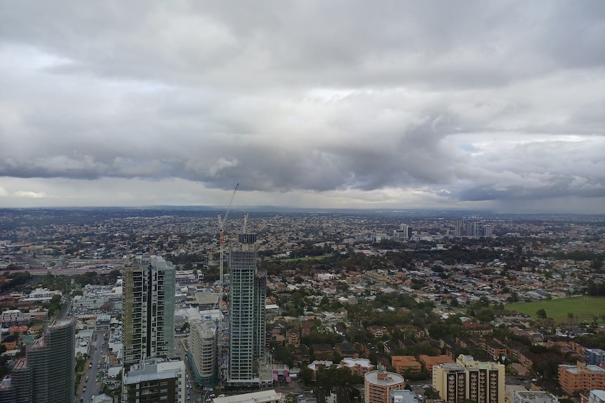 a dark cloud band hangs over the sydney skyline