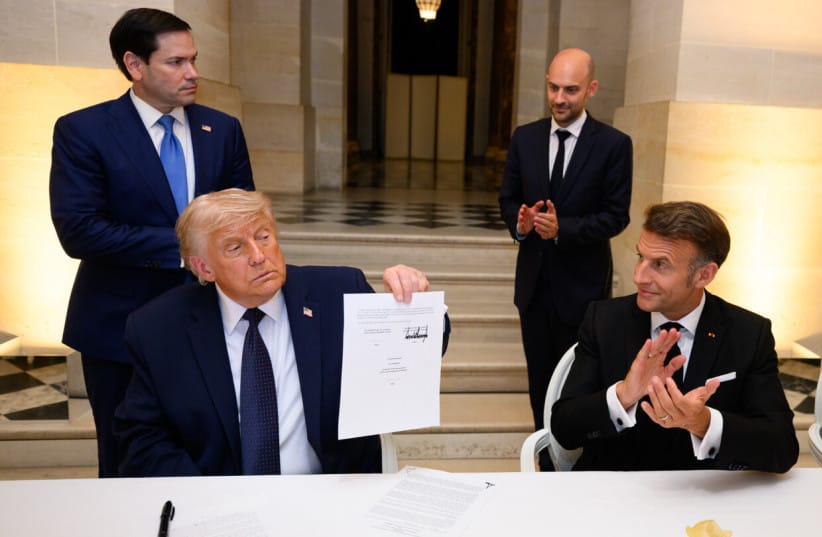 US President Donald Trump holds up the memorandum of understanding, signed by the US, and Iran, at the Palace of Versailles, in France.