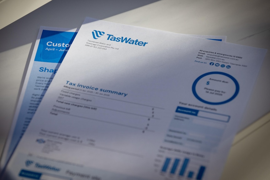 Two pages on a desk showing a TasWater bill.