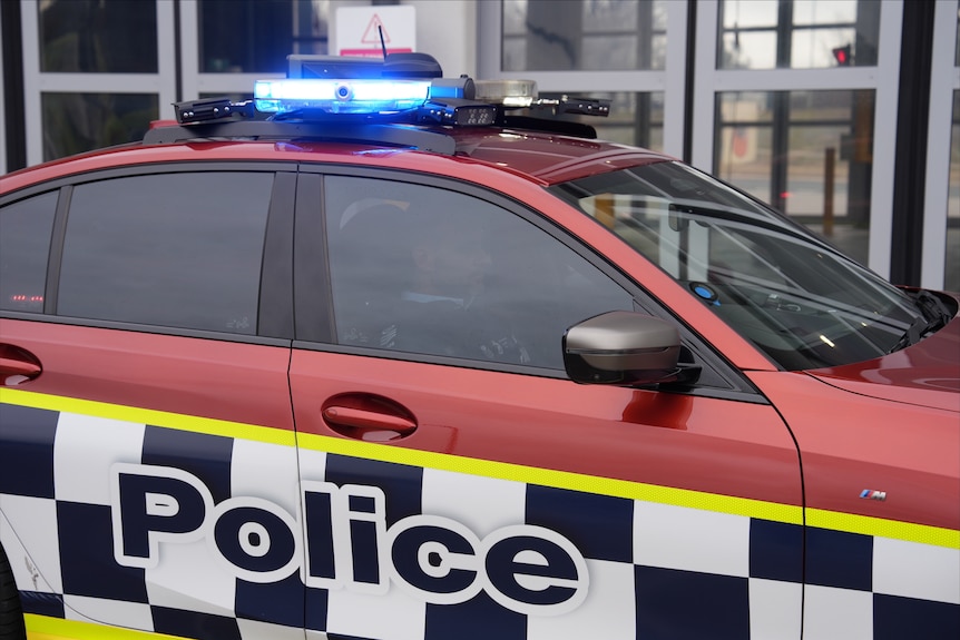 A red Australian Federal Police car from the side.
