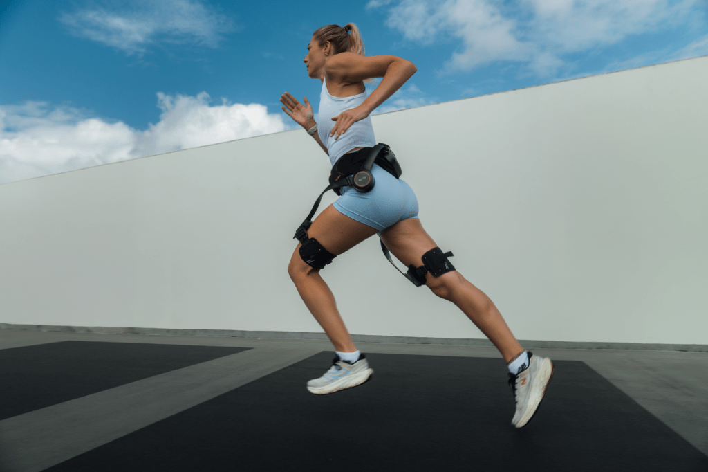 A woman running while wearing a Hypershell PD device.