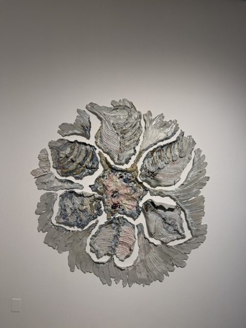 Circular abstract relief sculpture featuring textured layered forms and metallic surfaces in Heavy Metal.