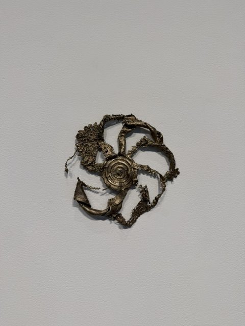 Small circular metal wall sculpture with organic textures featured in Heavy Metal at Barnsdall Art Park.