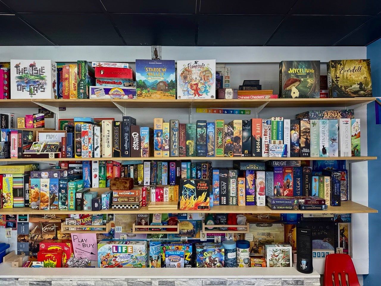 A wall of shelves filled with board games available to play at BUBS on Berks Street in East Kensington. The shelves are filled with many games.