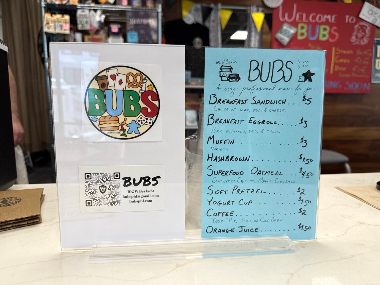 BUBS signs inside the small breakfast and games spot. The menu is simple and the food is affordable. A breakfast sandwich listed for $5. Coffee for $2.