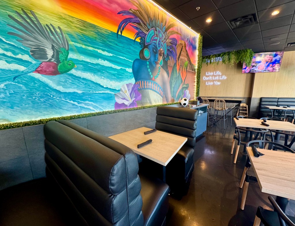 A vibrant mural of a Mayan goddess near the ocean overlooks the dining room at PoNy's Miches Michelada Bar & Grill.