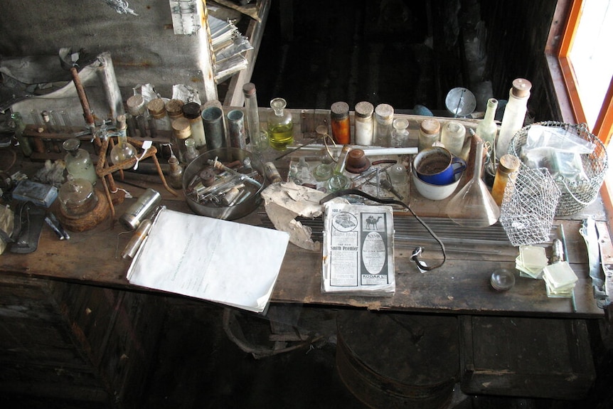 Bottles, notepads, equipment and other artefacts on a bench inside Scott's Terra Nova Hut.