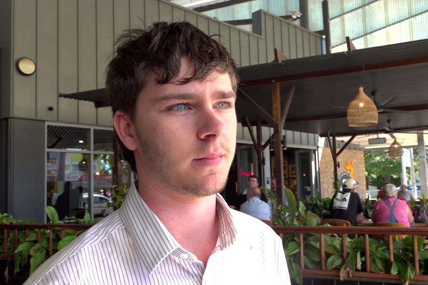 Man with blue eyes and dark hair looks off centre